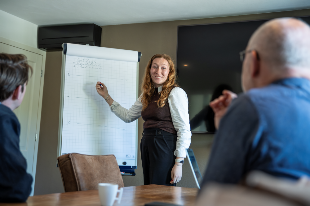 Joëlla Bax presenteert bij een whiteboard. Ter illustratie bij de vacature projectmanager gebiedsontwikkeling